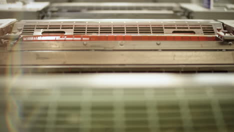 printing machine with a roller covered in light red color turning on the machine