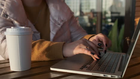 mujer trabajando en una computadora portátil en un café