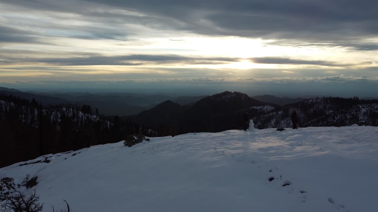 gente haciendo un muñeco de nieve en la cima de la roca del atardecer, parque nacional secoya