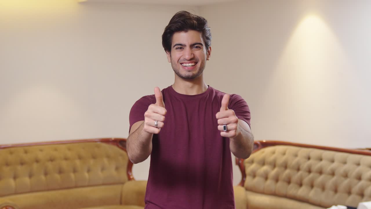 hombre indio feliz mostrando los pulgares hacia la cámara