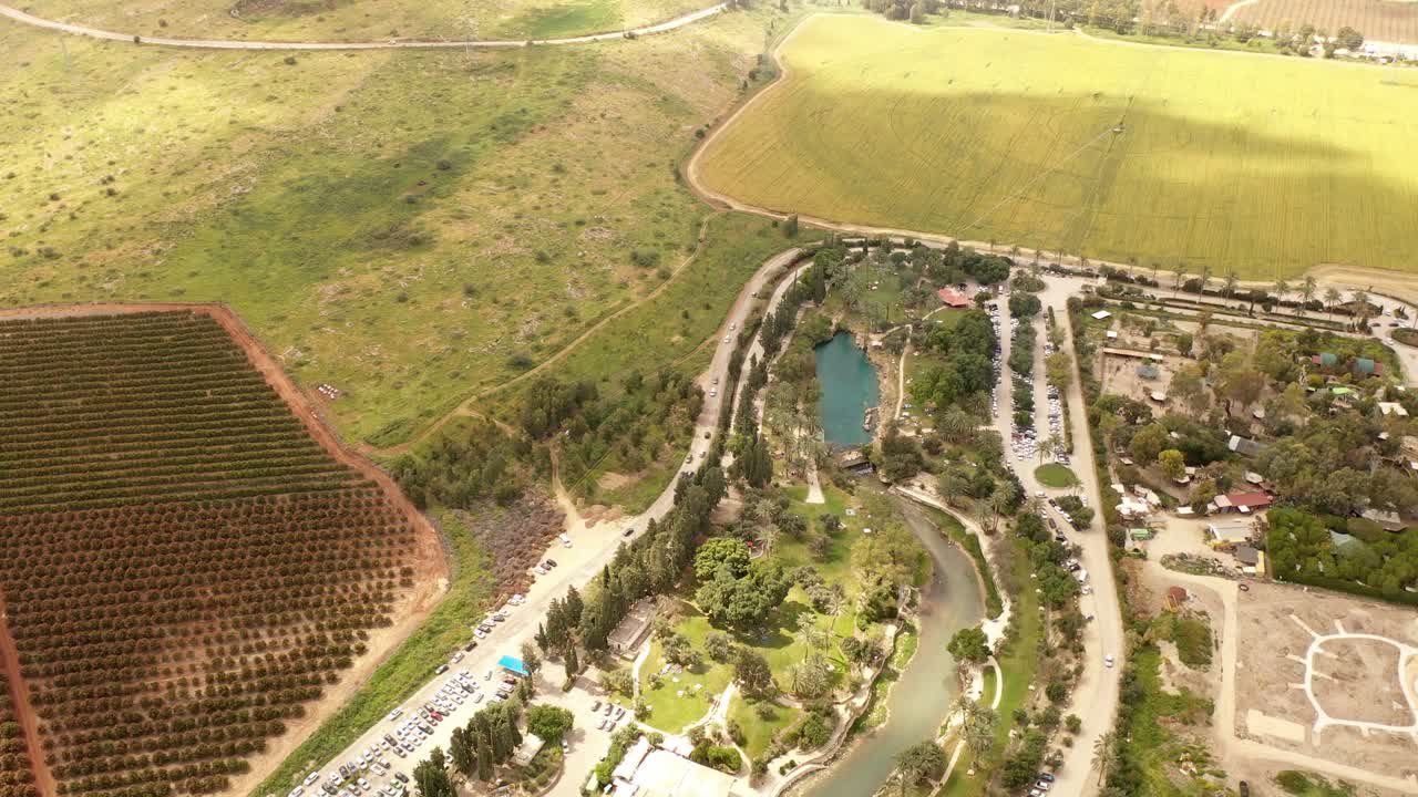 vista aérea de un paisaje rural con campos agrícolas y un manantial