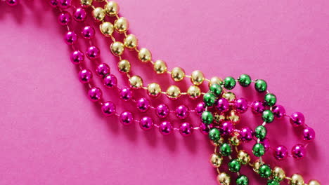 video de rosas, doradas y verdes cuentas de carnaval de mardi gras en fondo rosado