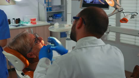 old woman at dentist having dental treatment