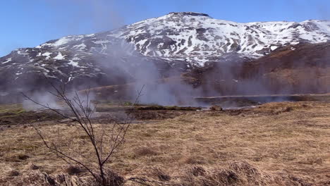 steam coming from the puddles of water created by a geyser in iceland