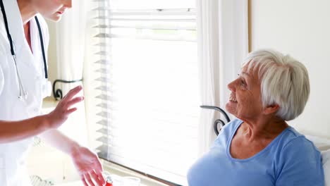 Female-doctor-serving-breakfast-to-senior-woman-in-the-bedroom