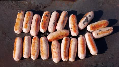 pork sausages cooking on an open fire barbecue