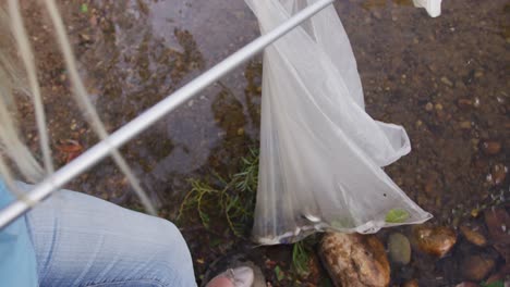 mujer caucásica voluntaria durante el día de limpieza del río