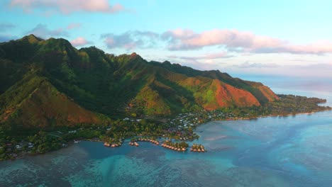 golden hour sunny sunset water bungalows cooks opunohu bay moorea island french polynesia aerial drone mount mauaroa tohivea rotui clouds boats lagoon coral reef waves pacific ocean circle right