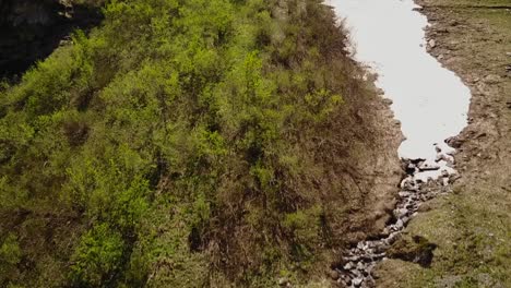 Drone-Ascendiendo-Y-Pasando-De-Un-Río-A-Un-Glaciar,-En-Los-Alpes-Suizos