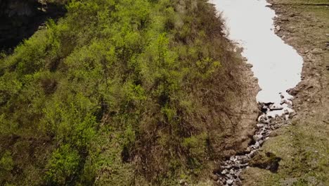 drone ascendiendo y pasando de un río a un glaciar, en los alpes suizos
