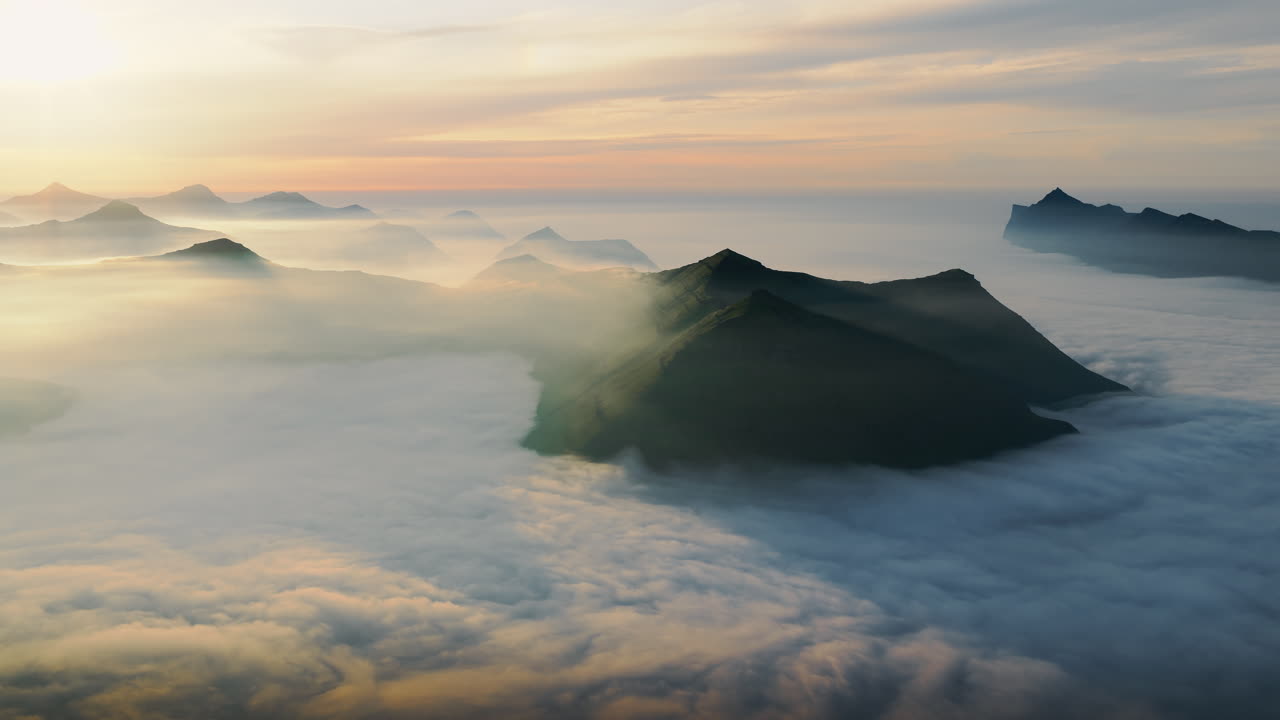 Majestic Mountain Peaks Emerging from a Sea of Clouds at Sunrise