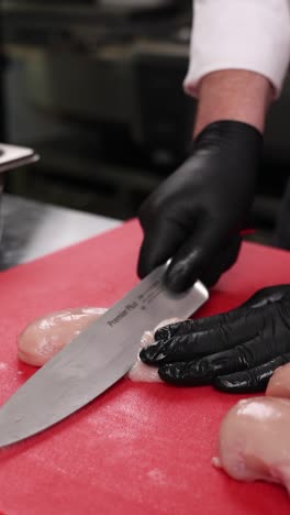 chef preparing raw chicken breast