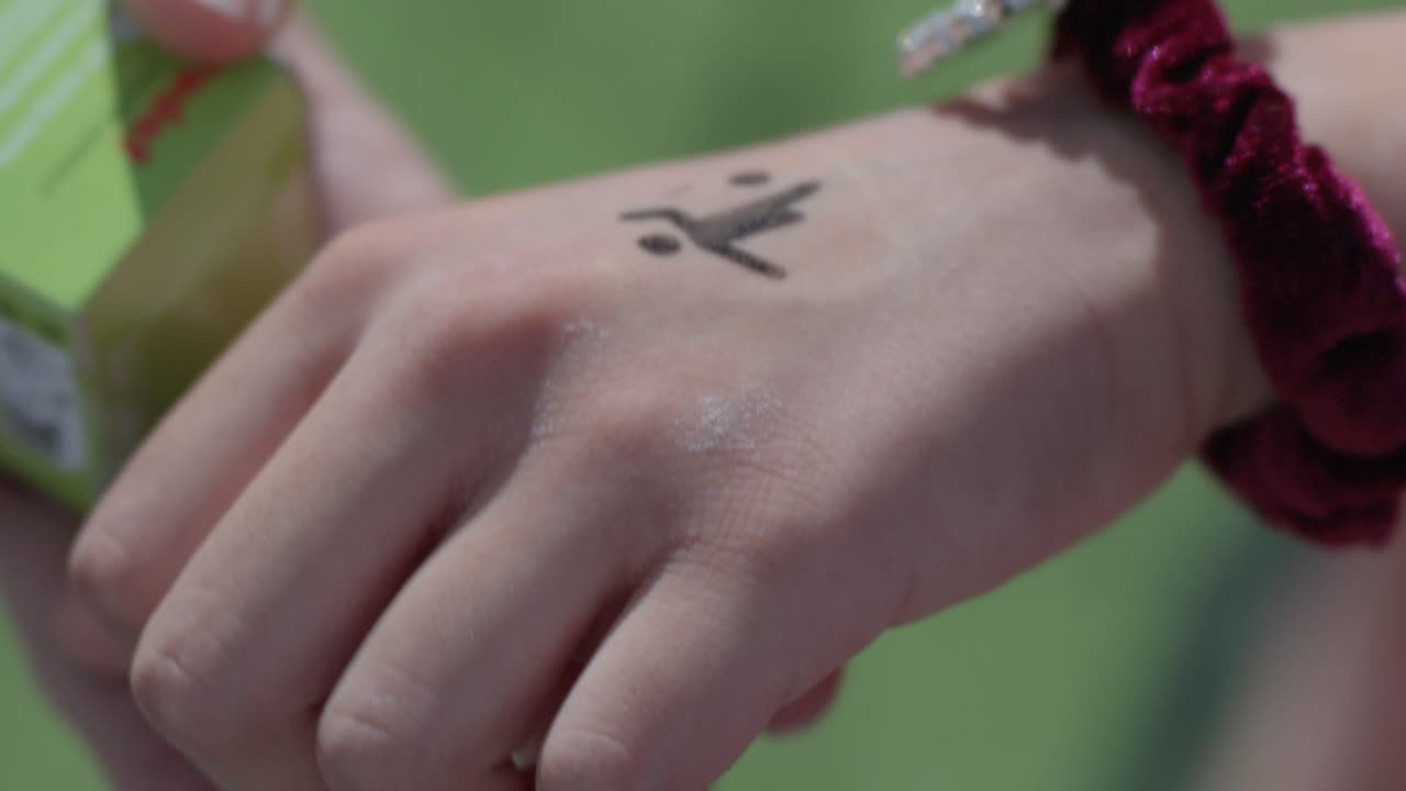 black ink stamp pressed on skin leaving a playful mark on wrist