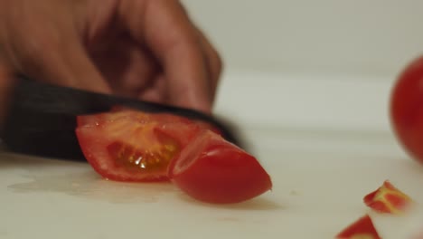 man´s hand cutting tomato for dinner