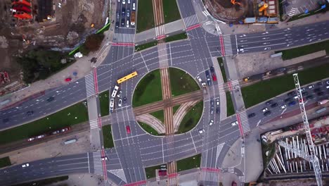 aerial city view, flying over a city, a suggestive perpendicular aerial video above a traffic roundabout with a lot of traffic