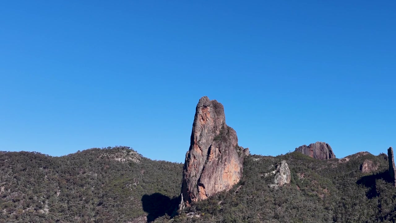 Bredt statisk billede af vulkanklippen The Breadknife under en klar blå himmel i Australien.