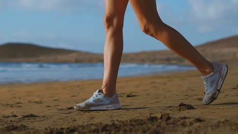 Nahaufnahme-Einer-Frau-In-Weißen-Turnschuhen,-Die-Am-Strand-Mit-Wunderschönem-Weißen-Sand-Spaziert.-Steadicam-In-Zeitlupe