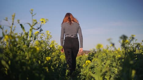 following shot of a women walking through a flower field in slow motion
