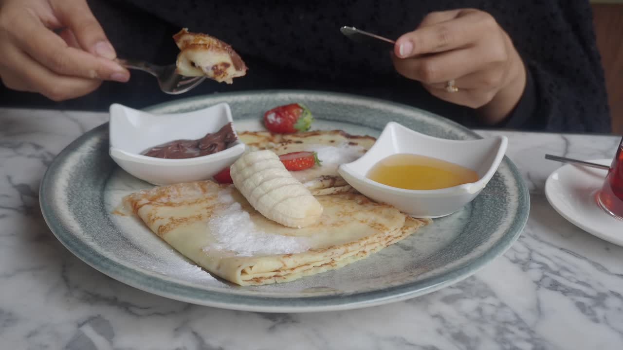 Pancakes with banana, strawberry, and honey