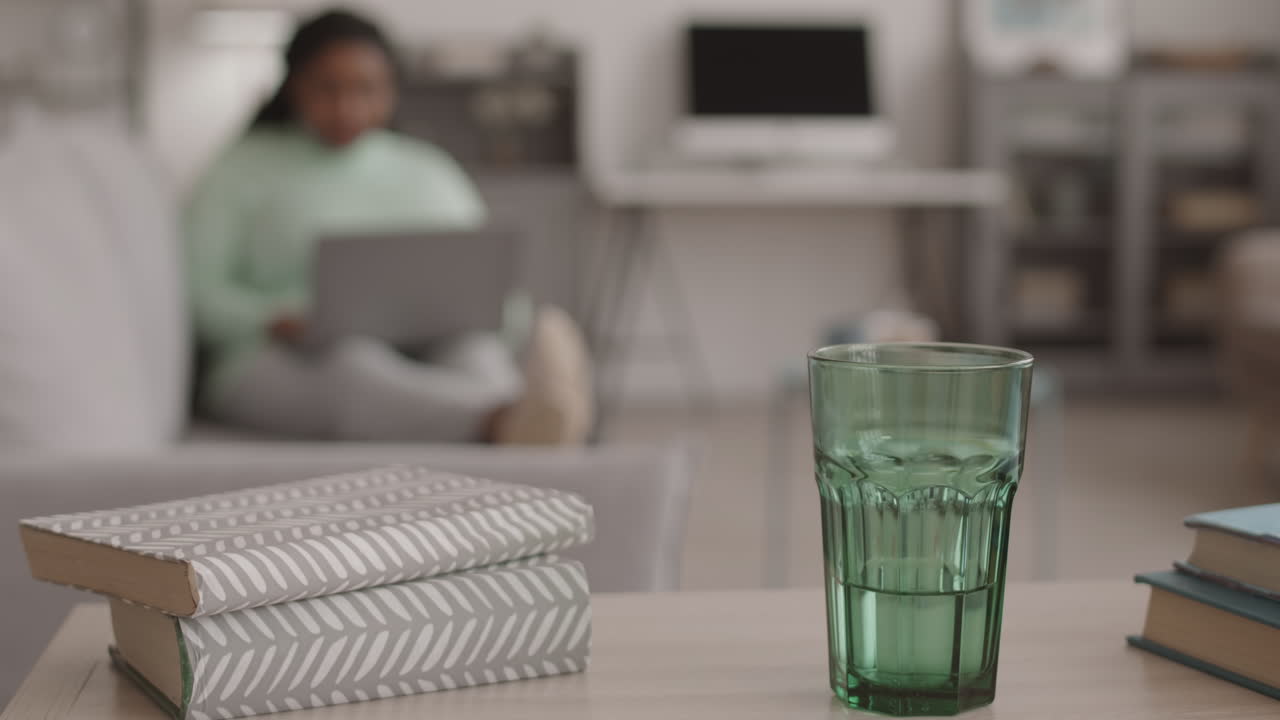 Glass and Books Lying on Desk in Living Room