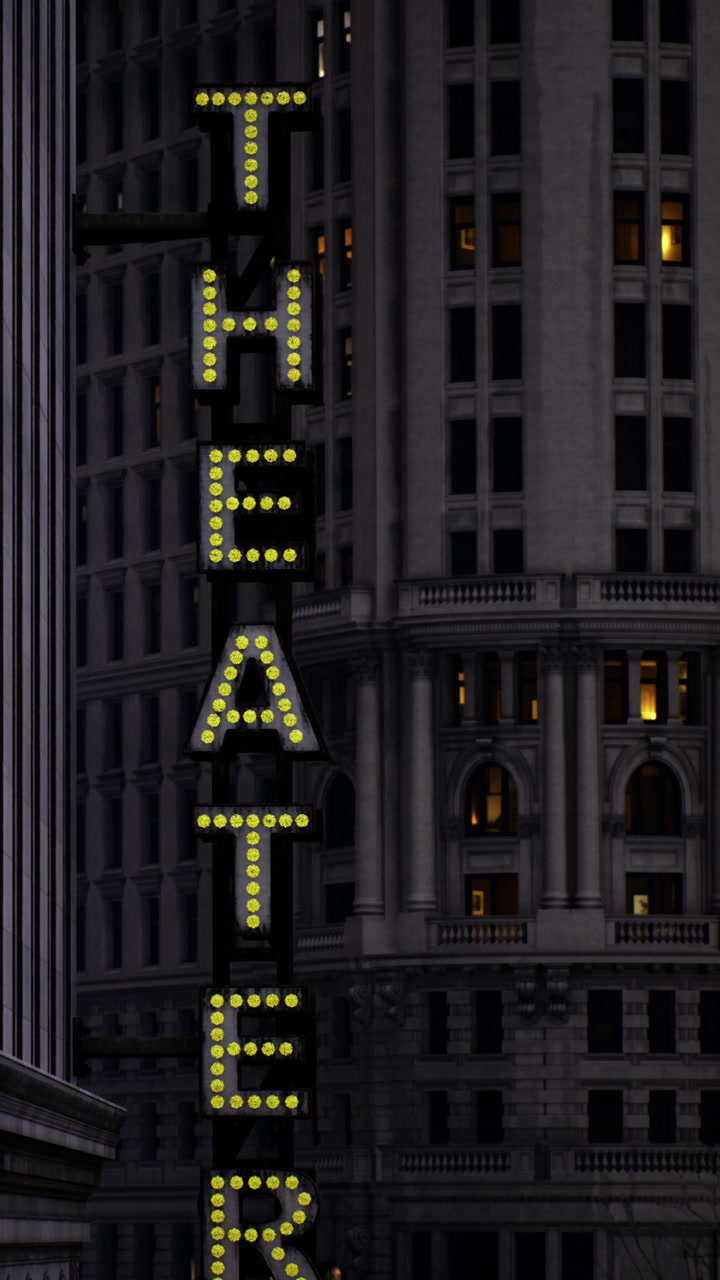 Sign highlights theater in urban setting at night with lit windows