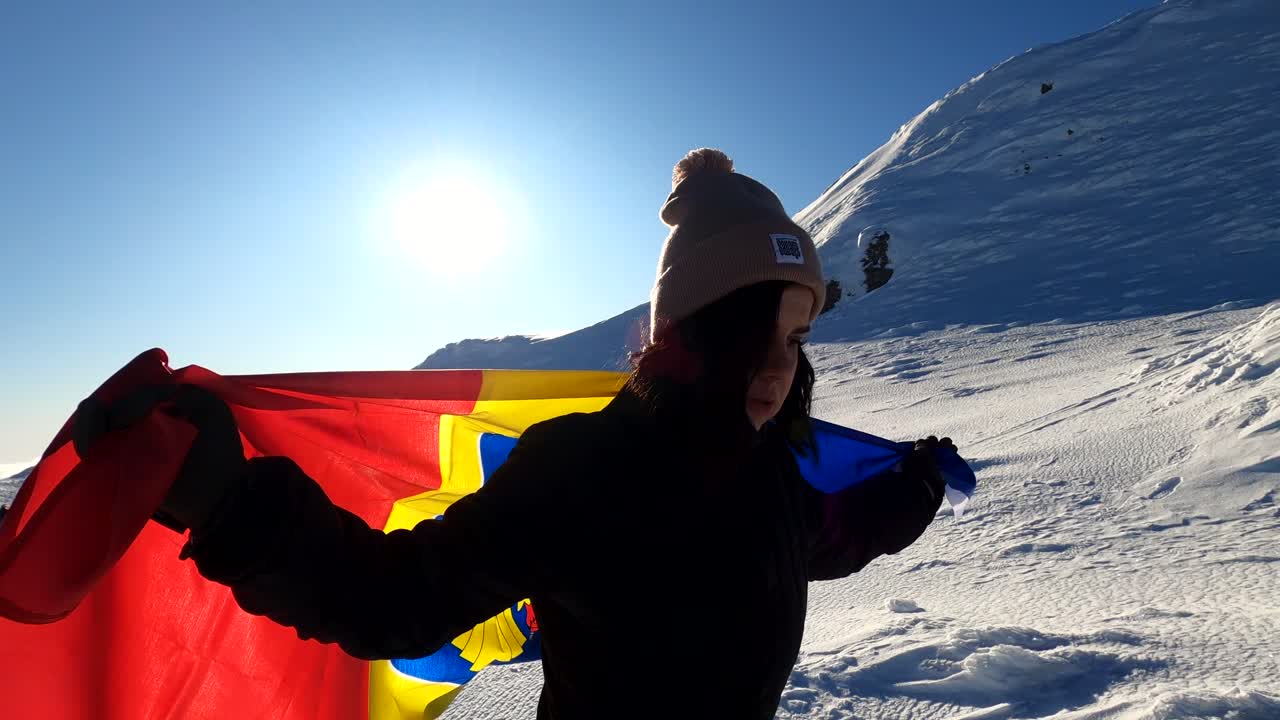 Woman running with a Romanian Flag on top of The Bucegi Mountains in Romania - slow motion shot