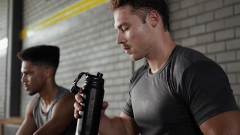 men resting and hydrating after a workout