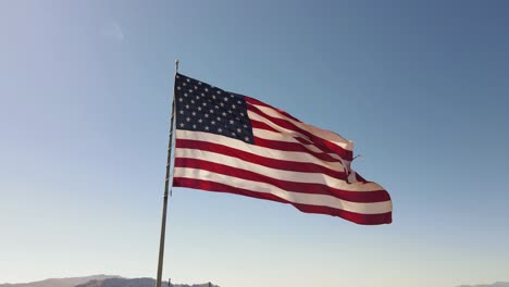 american flag blowing in wind, blue sky background