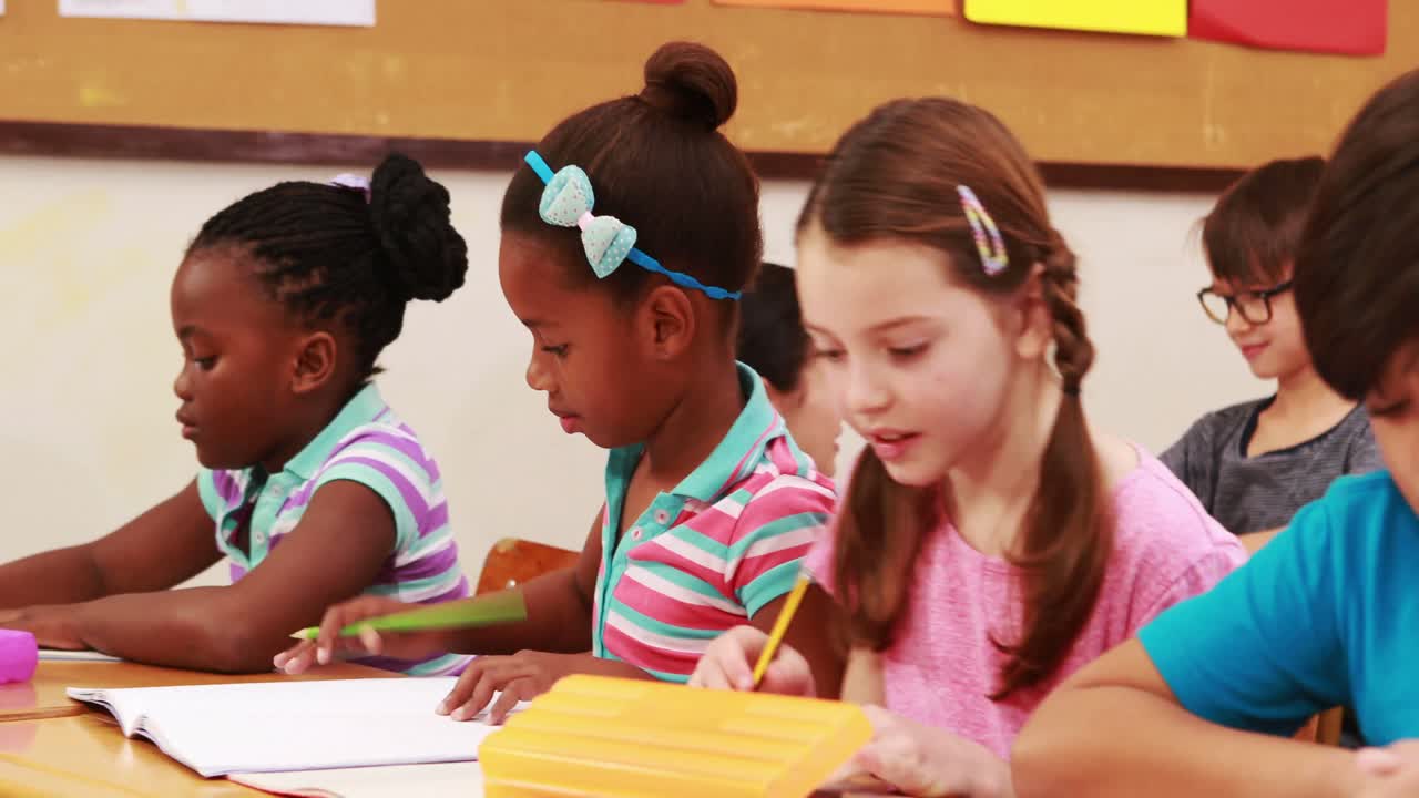 Teacher helping pupil with laptop