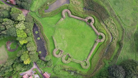 Aerial-video-footage-of-the-remains-of-Bolingbroke-Castle-a-13th-century-hexagonal-castle,-birthplace-of-the-future-King-Henry-IV,-with-adjacent-earthwork