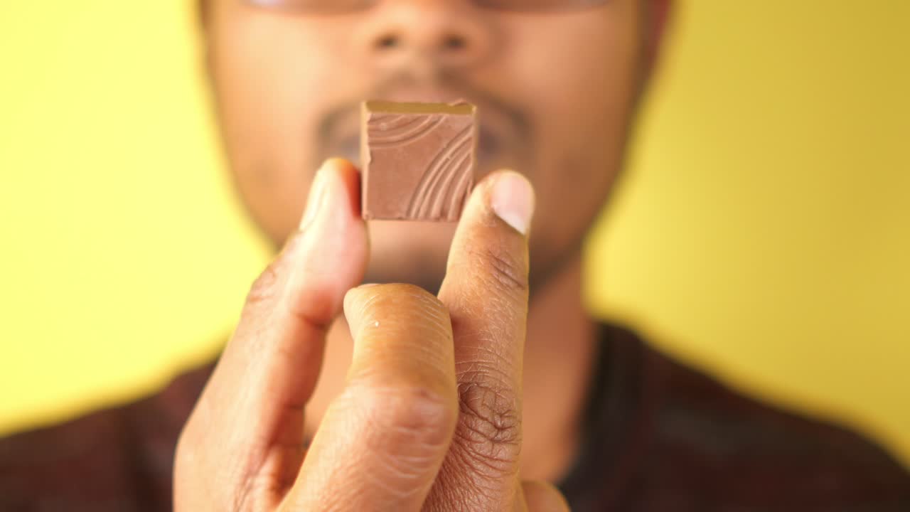 Man Holding a Piece of Chocolate