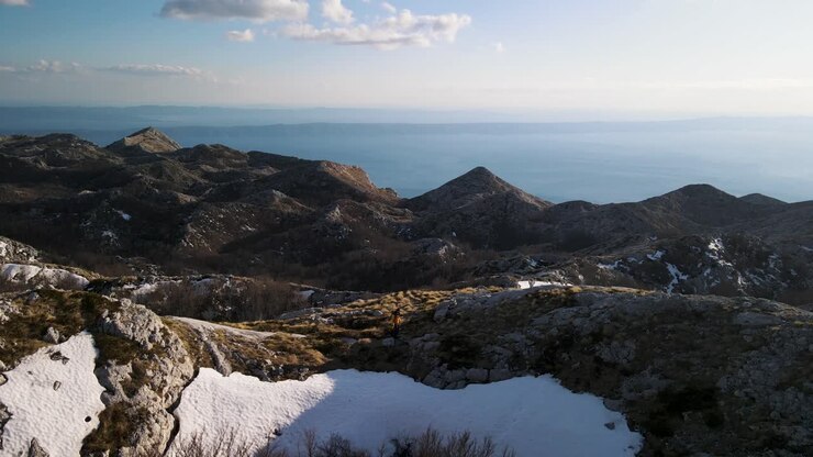 Escursionista tra montagne innevate in una giornata di sole, Sveti Jure Park prirode Biokovo