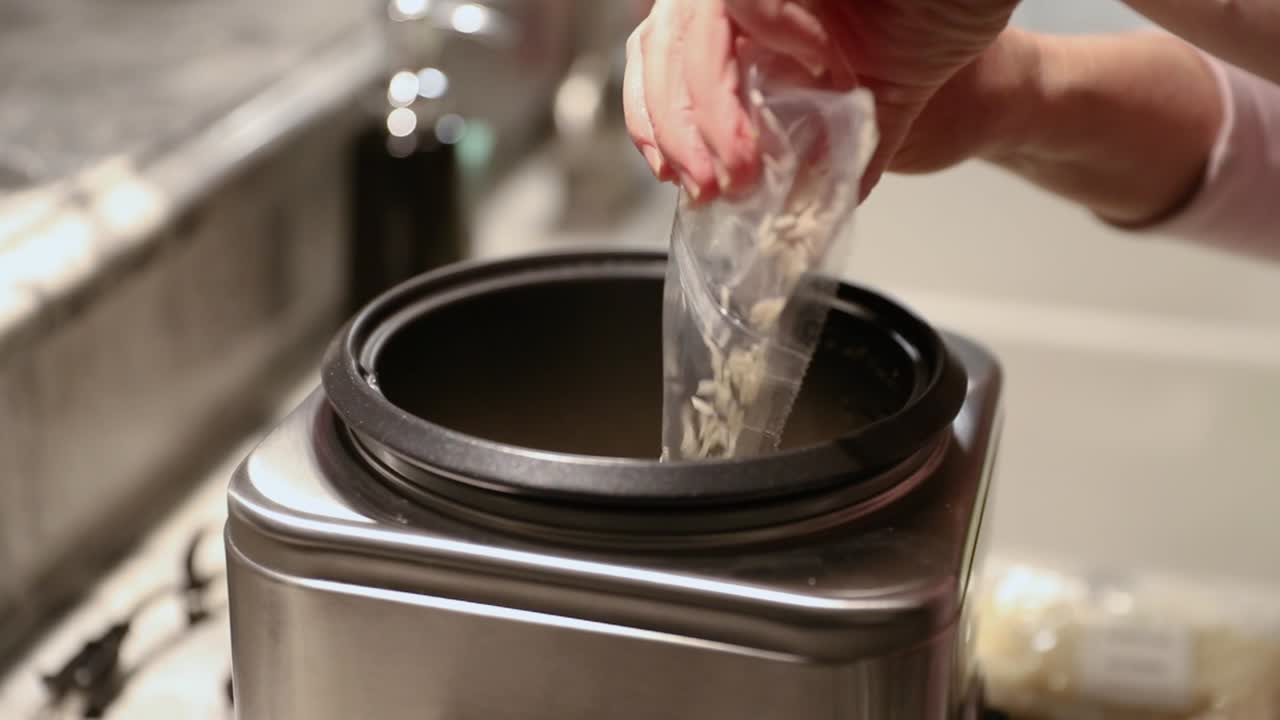 mujer vertiendo arroz en la olla arrocera en cámara lenta