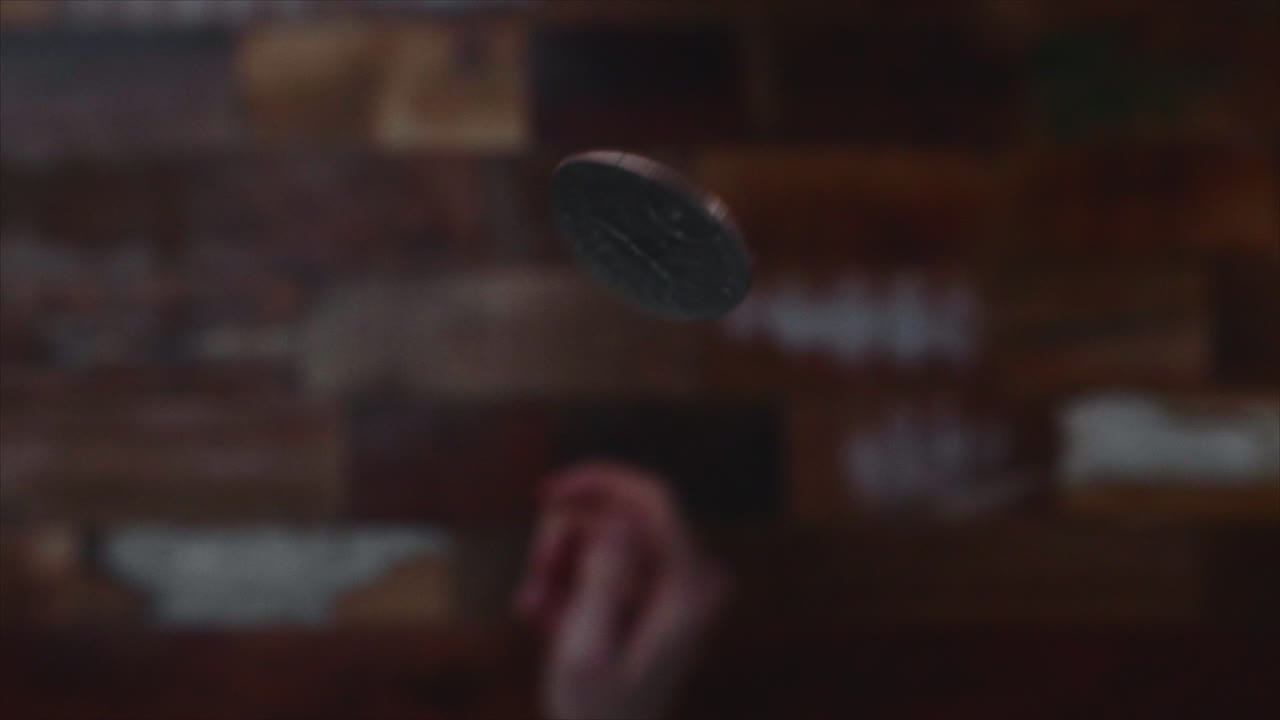 Blurry Shot Of Hand Throwing Coin In Focus