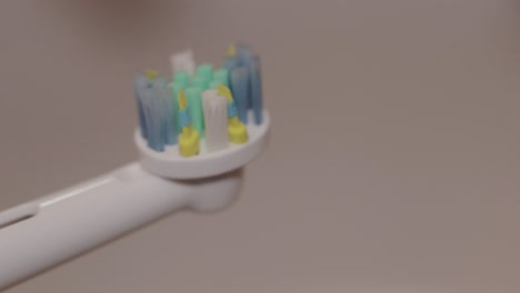 detail shot of mint toothpaste layered on an electric toothbrush