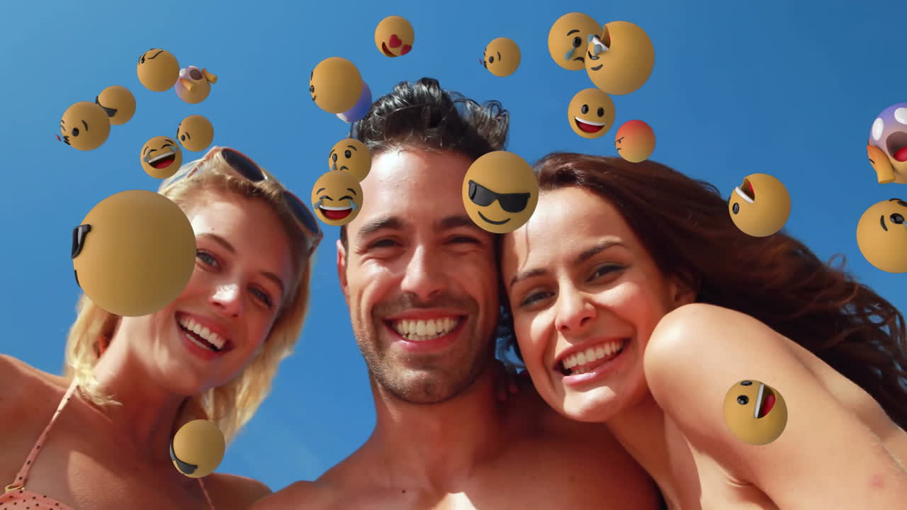 amigos sonrientes con animación de emoji flotante sobre el cielo azul claro