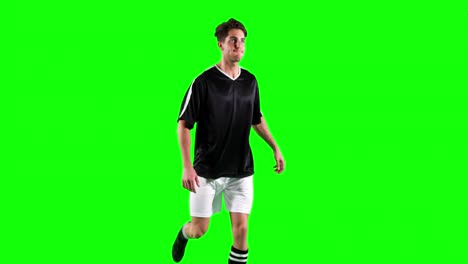 athlete practicing soccer against green screen