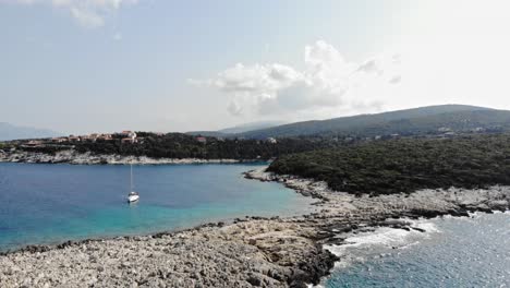 Luxury-Boat-Floating-Near-Emplisi-Beach-Rugged-Shore-In-Kefalonia,-Ionian-Islands,-Greece