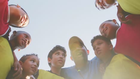 Niños-De-Fútbol-Reunidos-En-Círculo-En-Un-Día-Soleado