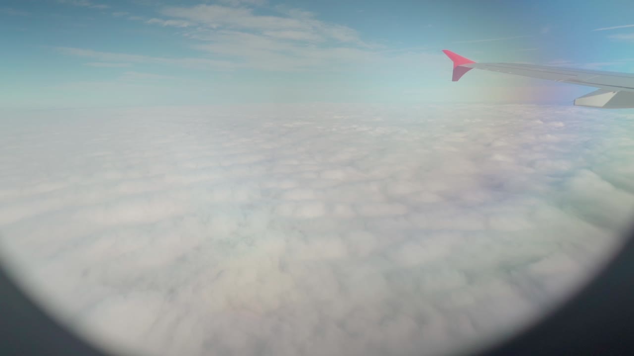 View from airplane window over the clouds