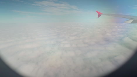 view from airplane window over the clouds