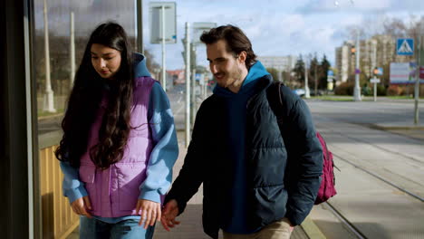 pareja caminando hacia la parada de autobús