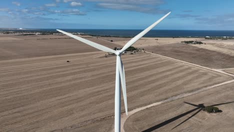 tracking drone shot of spinning wind turbine