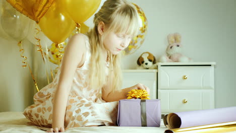 Blondes-Mädchen-7-Jahre-Wickelte-Eine-Schachtel-Mit-Geschenken-In-Papiergeburtstagsgeschenkkonzept-Ein