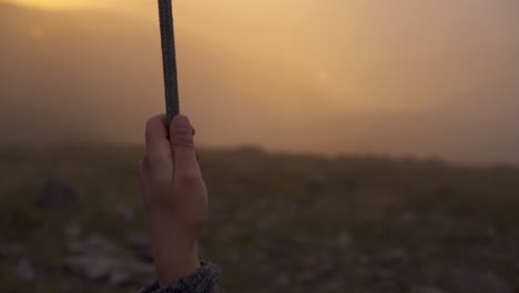 woman hand swinging on a swing in lousa baloico at sunset, portugal