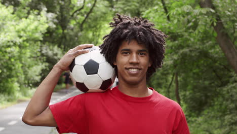 young man with soccer ball in park