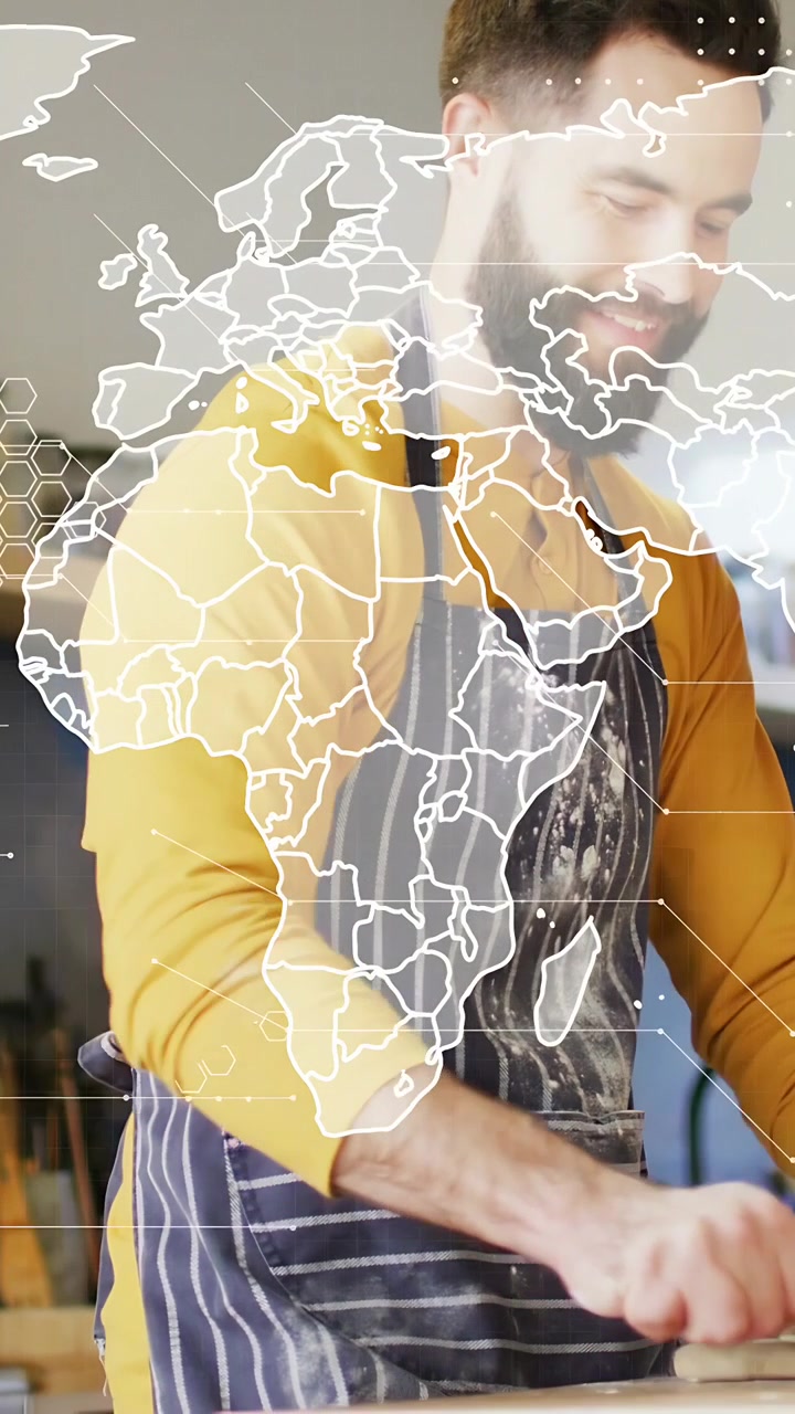 Video verticale: Panettiere che si china e impasta la pasta mentre una mappa del mondo si sovrappone al panettiere, che prepara l'impasto.