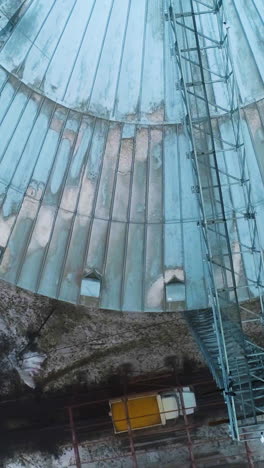 huge harvesting grain tanks. big industrial elevator metal construction. vertical video