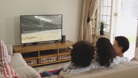 Compuesto-De-Familia-Feliz-Sentados-Juntos-En-Casa-Viendo-Atletismo-De-Salto-De-Longitud-En-La-Televisión