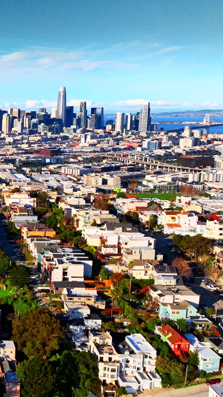 Vista panoramica dello skyline del centro di San Francisco, California. Veduta dall'alto che mostra i densi grattacieli del quartiere finanziario, i blocchi residenziali e il Bay Bridge sotto un cielo azzurro limpido. Video verticale